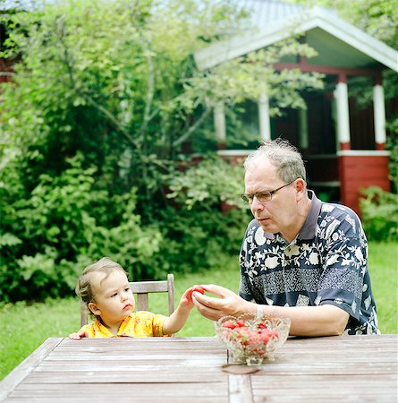 simsearch:6126-08644686,k - Finland, Uusimaa, Lapinjarvi, Grandfather giving strawberry to granddaughter (2-3) Stock Photo - Premium Royalty-Free, Code: 6126-08644687