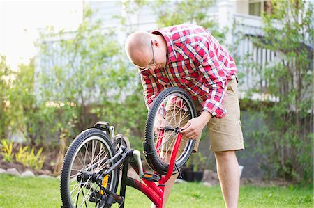 simsearch:6126-08644873,k - Finland, Keski-Suomi, Jyvaskyla, Man fixing kids bicycle Foto de stock - Sin royalties Premium, Código: 6126-08644759