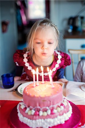 dress blowing - Finland, Girl (4-5) blowing out candles on birthday cake Stock Photo - Premium Royalty-Free, Code: 6126-08644735