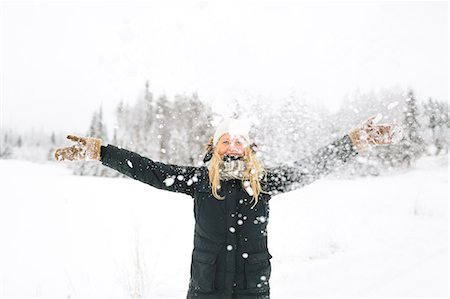 finlande - Finland, Jyvaskyla, Saakoski, Smiling woman with falling snow in foreground Stock Photo - Premium Royalty-Free, Code: 6126-08644868