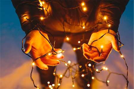 Finland, Jyvaskyla, Saakoski, Young man holding Christmas lights Stock Photo - Premium Royalty-Free, Code: 6126-08644873