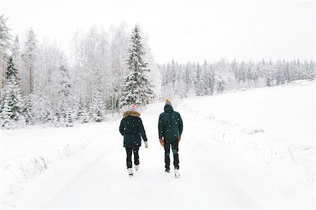 Finland, Jyvaskyla, Saakoski, Young couple walking along road covered with snow Stock Photo - Premium Royalty-Free, Code: 6126-08644874