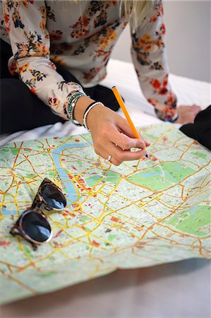 simsearch:6126-08659298,k - United Kingdom, England, London, Close-up of young woman examining map on bed Stock Photo - Premium Royalty-Free, Code: 6126-08644880