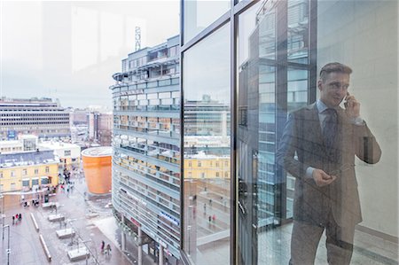 stand (structure for holding objects) - Finland, Helsinki, Businessman seeing through window talking by phone Foto de stock - Sin royalties Premium, Código: 6126-08644900