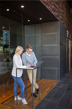 Finland, Colleagues using laptop in lobby Stock Photo - Premium Royalty-Free, Code: 6126-08644914