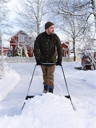 Finland, Pohjanmaa, Pietarsaari, Kruunupyy, Man cleaning yard with snow pusher Photographie de stock - Premium Libres de Droits, Code: 6126-08644915