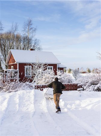 snowy houses - Finland, Pohjanmaa, Pietarsaari, Kruunupyy, Man cleaning yard with snow pusher Stock Photo - Premium Royalty-Free, Code: 6126-08644916