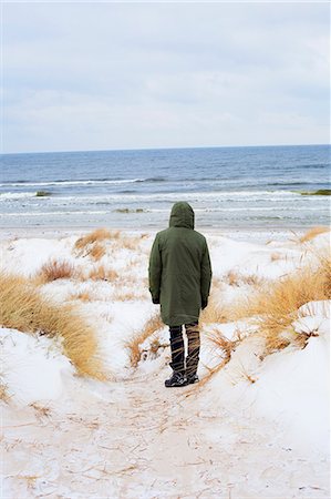 simsearch:6126-09102797,k - Sweden, Skane, Borrby, Rear view of mid adult man standing on beach in winter Foto de stock - Royalty Free Premium, Número: 6126-08658869