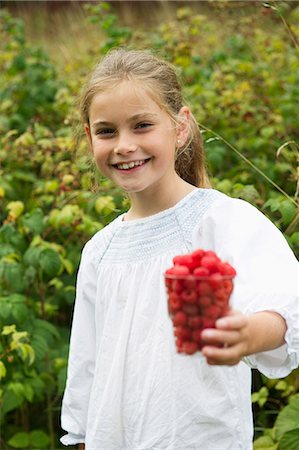 fresh raspberries and outdoors - Sweden, Stockholm, Girl (8-9) with cup of raspberries Stock Photo - Premium Royalty-Free, Code: 6126-08658934