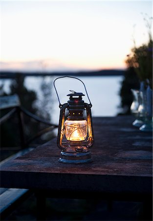 even - Sweden, Stockholm, Dalaro, Lantern on table at dusk Foto de stock - Sin royalties Premium, Código: 6126-08658938