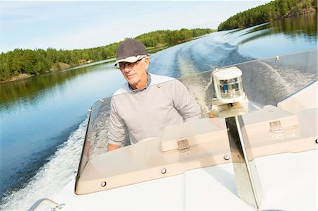 simsearch:6126-08659056,k - Sweden, Ostergotland, Senior man driving motorboat Stockbilder - Premium RF Lizenzfrei, Bildnummer: 6126-08659053