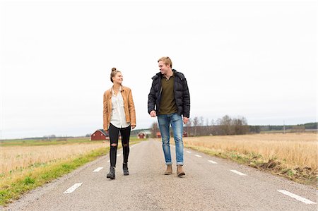 simsearch:6126-08658998,k - Sweden, Ostergotland, Mjolby, Teenage girl (14-15) and young man walking along country road Stock Photo - Premium Royalty-Free, Code: 6126-08659059