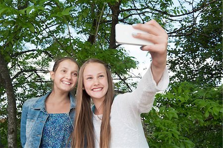 simsearch:6126-08781199,k - Sweden, Vastra Gotaland, Gothenburg, Two smiling girls (14-15) taking selfie Fotografie stock - Premium Royalty-Free, Codice: 6126-08659021