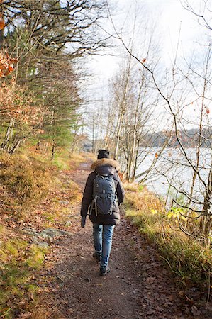 simsearch:6126-08636688,k - Sweden, Vastergotland, Lerum, Lake Aspen, Woman on footpath by lake Photographie de stock - Premium Libres de Droits, Code: 6126-08659254