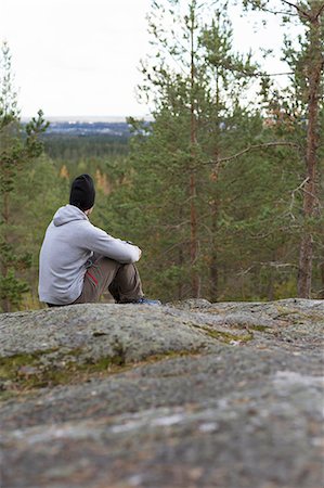 pantalón de sudadera - Sweden, Vasterbotten, Umea, Mid adult man sitting on rocks looking at view Photographie de stock - Premium Libres de Droits, Code: 6126-08659283