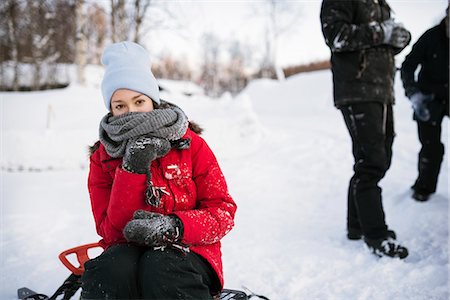 simsearch:6126-08635432,k - Sweden, Lapland, Hemavan, Young woman sitting on sled in winter Fotografie stock - Premium Royalty-Free, Codice: 6126-08659317