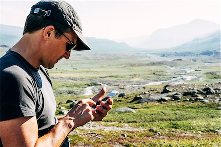 simsearch:6126-08659254,k - Sweden, Lapland, Ladtjovagge, Kungsleden, Male hiker using smart phone Fotografie stock - Premium Royalty-Free, Codice: 6126-08635051