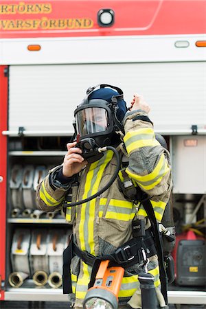 Sweden, Female firefighter putting on protective mask Stock Photo - Premium Royalty-Free, Code: 6126-08635159