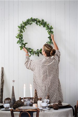 simsearch:6126-08644248,k - Sweden, Woman hanging Christmas wreath on wall Photographie de stock - Premium Libres de Droits, Code: 6126-08635347