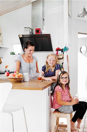 Sweden, Mother and daughters (6-7, 8-9) smiling in kitchen Photographie de stock - Premium Libres de Droits, Code: 6126-08635344