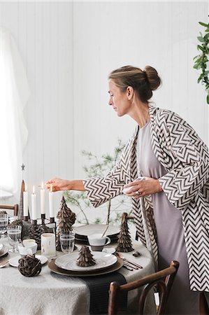 simsearch:6126-08644248,k - Sweden, Woman lighting candles during Christmas Photographie de stock - Premium Libres de Droits, Code: 6126-08635350