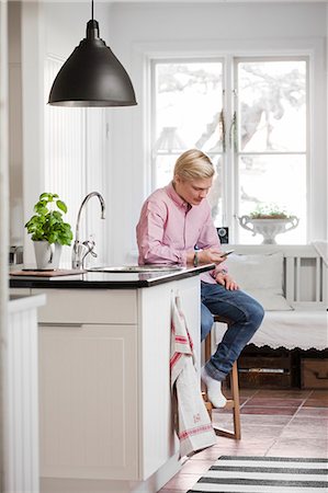 swedish - Sweden, Teenage boy (16-17) texting in kitchen Stock Photo - Premium Royalty-Free, Code: 6126-08635337