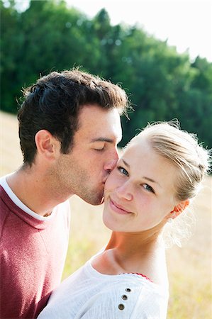 simsearch:614-06442432,k - Sweden, Vastra Gotaland, Kallandso, Young man kissing girlfriend's cheek Stock Photo - Premium Royalty-Free, Code: 6126-08635446