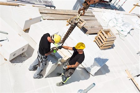 simsearch:6126-09104272,k - Sweden, Ostergotland, Linkoping, Construction workers adjusting blocks on construction site Stock Photo - Premium Royalty-Free, Code: 6126-08635552
