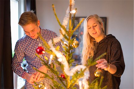 Sweden, Couple decorating Christmas tree Stock Photo - Premium Royalty-Free, Code: 6126-08635566
