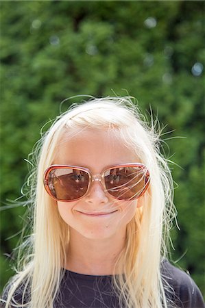 Sweden, Smaland, Anderstorp, Portrait of girl (10-11) wearing large sunglasses Stock Photo - Premium Royalty-Free, Code: 6126-08636035