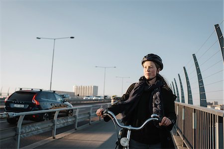 simsearch:6126-08644048,k - Sweden, Sodermanland, Stockholm, Vasterbron, Young woman walking with bike Photographie de stock - Premium Libres de Droits, Code: 6126-08636147