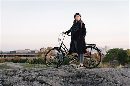 simsearch:6126-08644048,k - Sweden, Sodermanland, Stockholm, Sodermalm, Skinnarviksberget, Young woman standing by bicycle on rock Photographie de stock - Premium Libres de Droits, Code: 6126-08636151