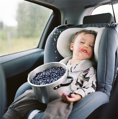 Finland, Uusimaa, Lapinjarvi, Portrait of girl (2-3) sleeping in car seat with pot full of blueberries on lap Foto de stock - Royalty Free Premium, Número: 6126-08636461