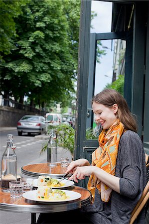 simsearch:6126-08636496,k - France, Ile-de-France, Paris, Young woman by table in sidewalk cafe Foto de stock - Sin royalties Premium, Código: 6126-08636482
