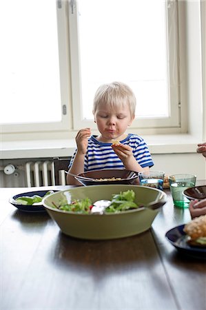 photo sitting on radiator - Finland, Helsinki, Kallio, Boy eating lunch Stock Photo - Premium Royalty-Free, Code: 6126-08636570