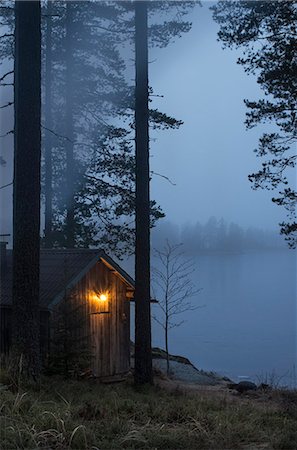 finnisch - Finland, Pirkanmaa, Ruovesi, Illuminated wooden cottage on foggy day Stockbilder - Premium RF Lizenzfrei, Bildnummer: 6126-08636774