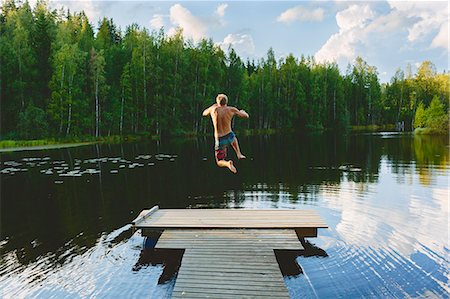 simsearch:6126-08636707,k - Finland, Keski-Suomi, Jyvaskyla, Lake Vuohijarvi, Young man jumping off pier into lake Stock Photo - Premium Royalty-Free, Code: 6126-08636710