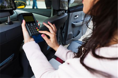 Sweden, Stockholm, Woman doing electronic payment in car Stock Photo - Premium Royalty-Free, Code: 6126-08781103