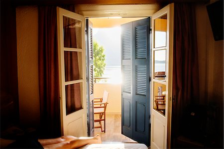 sunlight shutters - Greece, Kalymnos, Young woman lying down on bed in sunny bedroom Stock Photo - Premium Royalty-Free, Code: 6126-08781129