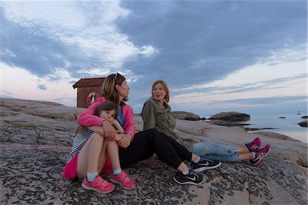 Sweden, Gotaland, Bohuslan, Grebbestad, Tjurpannan, Mature women and girl (6-7) sitting on rocky seashore Photographie de stock - Premium Libres de Droits, Code: 6126-08781245