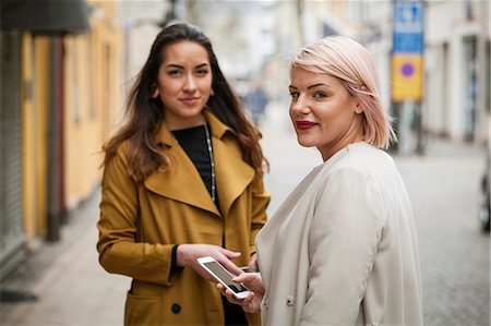 simsearch:6126-08781229,k - Sweden, Skane, Kirstianstad, Portrait of two young women on street Photographie de stock - Premium Libres de Droits, Code: 6126-08781256