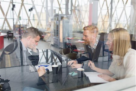 simsearch:6126-09104257,k - Sweden, Vasterbotten, Umea, Men and woman sitting at table with laptop and coffee seen through glass window Photographie de stock - Premium Libres de Droits, Code: 6126-08781214