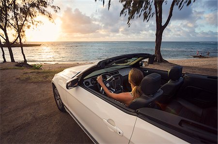 simsearch:6126-08635314,k - USA, Hawaii, Oahu, Banzai Pipeline, Mid adult woman watching sunset in convertible car at beach Stock Photo - Premium Royalty-Free, Code: 6126-08781389