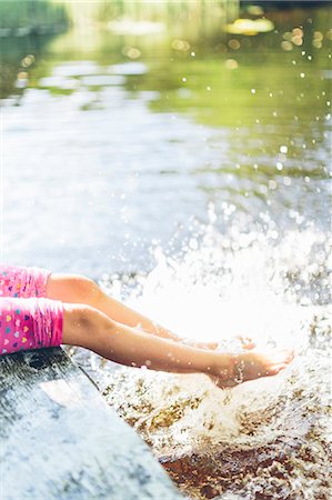 Sweden, Low section of girl (8-9) splashing water with legs Stock Photo - Premium Royalty-Free, Code: 6126-08781420