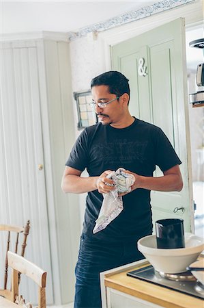 Sweden, Man drying dishes in kitchen Foto de stock - Sin royalties Premium, Código: 6126-08781439