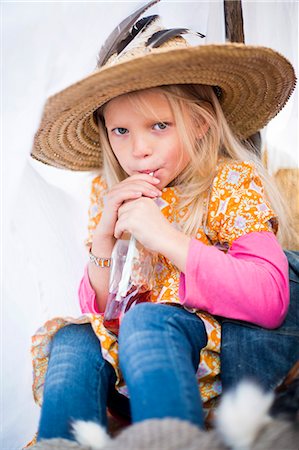 Finland, Central Finland, Aanekoski, Girl (8-9) wearing straw hat sitting in tent Stock Photo - Premium Royalty-Free, Code: 6126-08781552