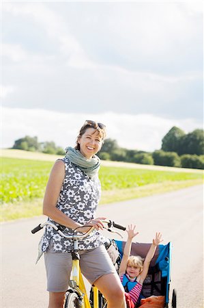simsearch:6102-08388194,k - A mother cycling with her young daughter in a bicycle trailer Foto de stock - Royalty Free Premium, Número: 6126-09102359