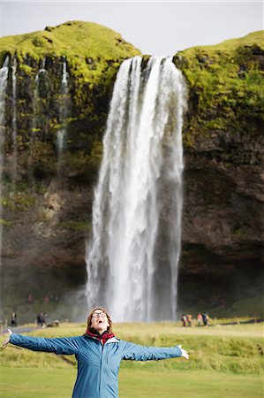 simsearch:6126-09103785,k - A woman standing with arms raised in front of a waterfall Foto de stock - Sin royalties Premium, Código: 6126-09102331