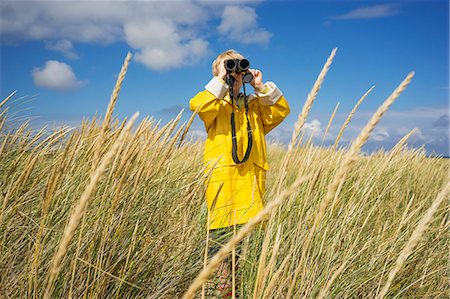 rain coat for boys - A young boy in wet weather gear looking through binoculars Stock Photo - Premium Royalty-Free, Code: 6126-09102408