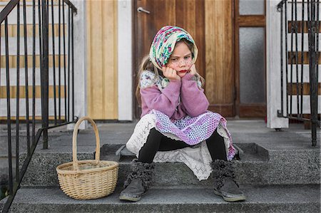 scandinavian ethnicity female - Pensive girl dressed up as Easter witch with Easter basket sitting on steps Stock Photo - Premium Royalty-Free, Code: 6126-09102547